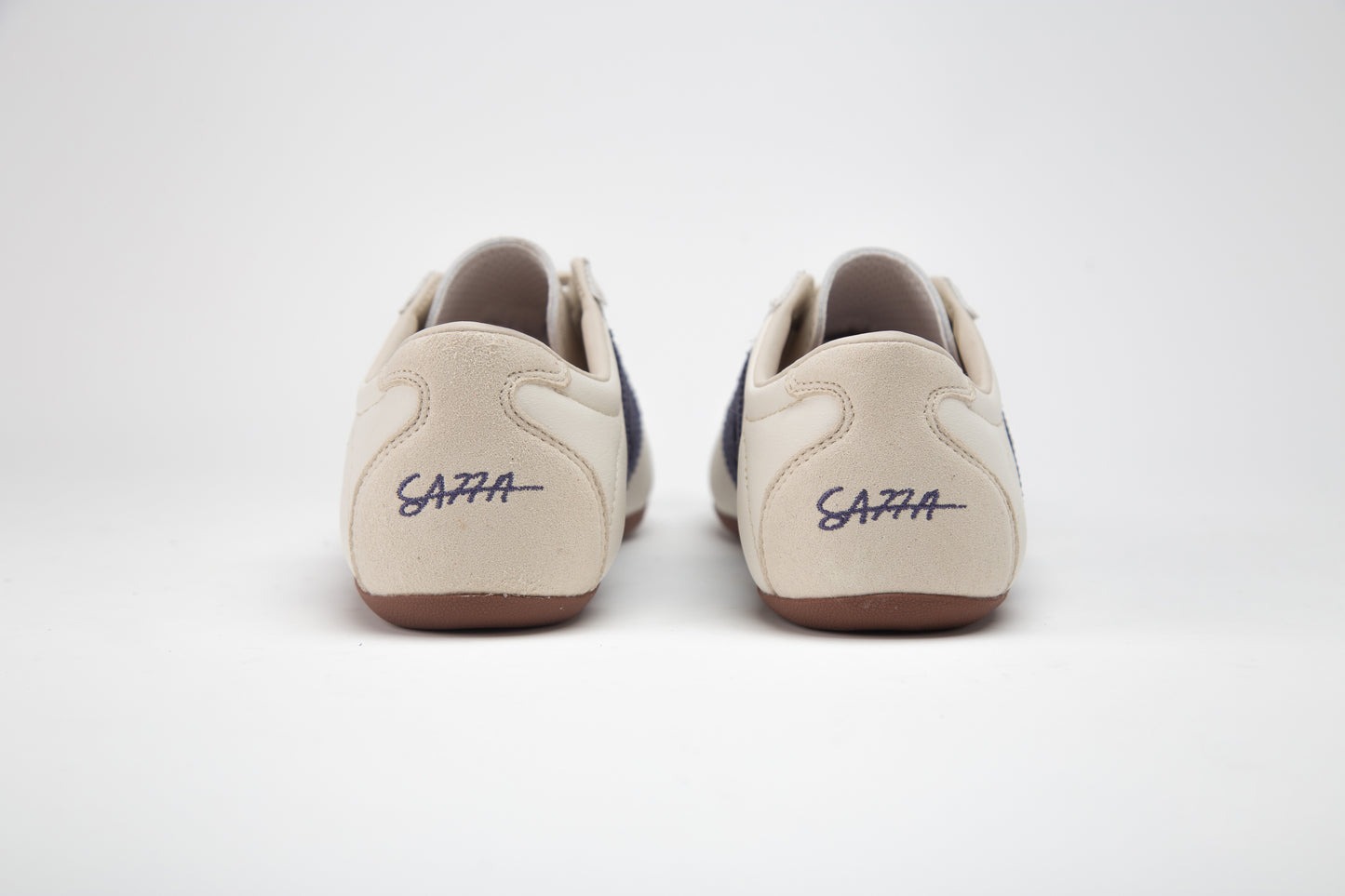 SA77A颯合 AMOY CROWN BLUE. The brand that spells H with double seven. Pair of white sneakers with a blue double seven logo on a light gray background