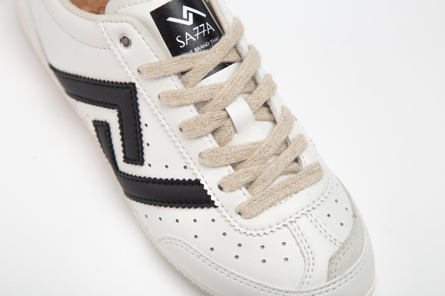SA77A 颯合White sneaker with black logo and beige laces on a white background