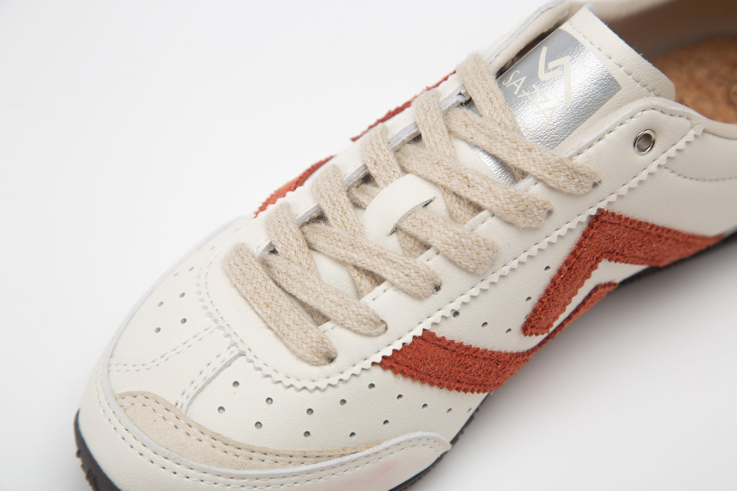 SA77A 颯合White sneaker with orange accents on a white background