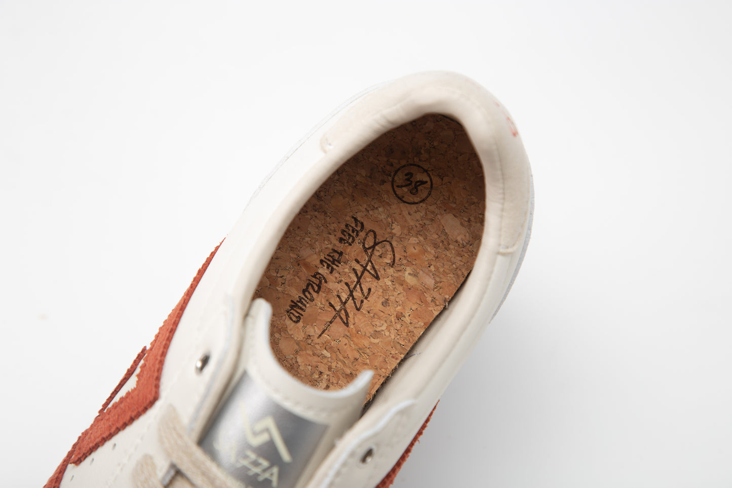 SA77A 颯合Close-up of a shoe with cork insole and brand logo on a white background