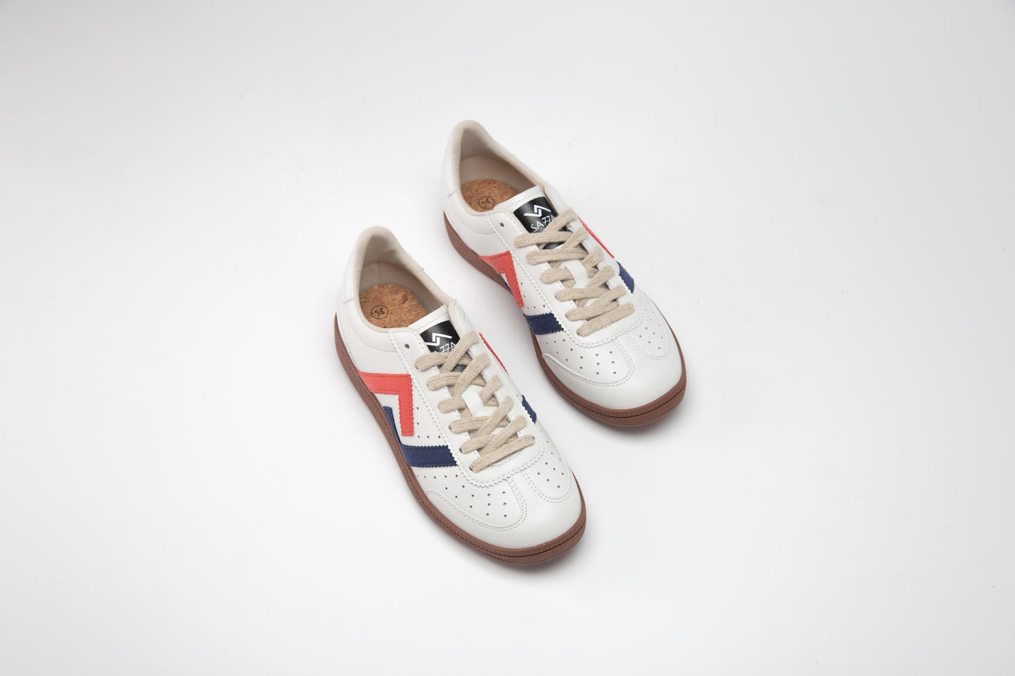 SA77A 颯合Pair of white sneakers with red and blue accents on a light gray background